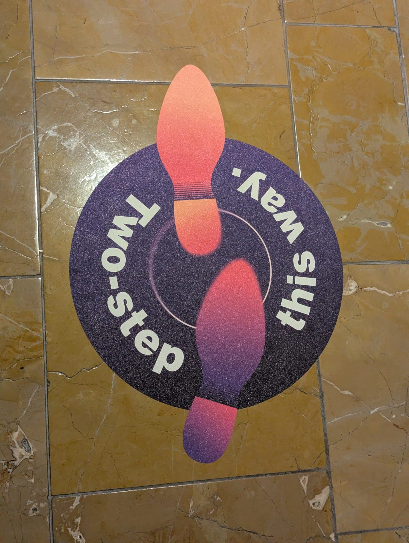 Floor cling of two cowboy boot prints reading Two-step this way